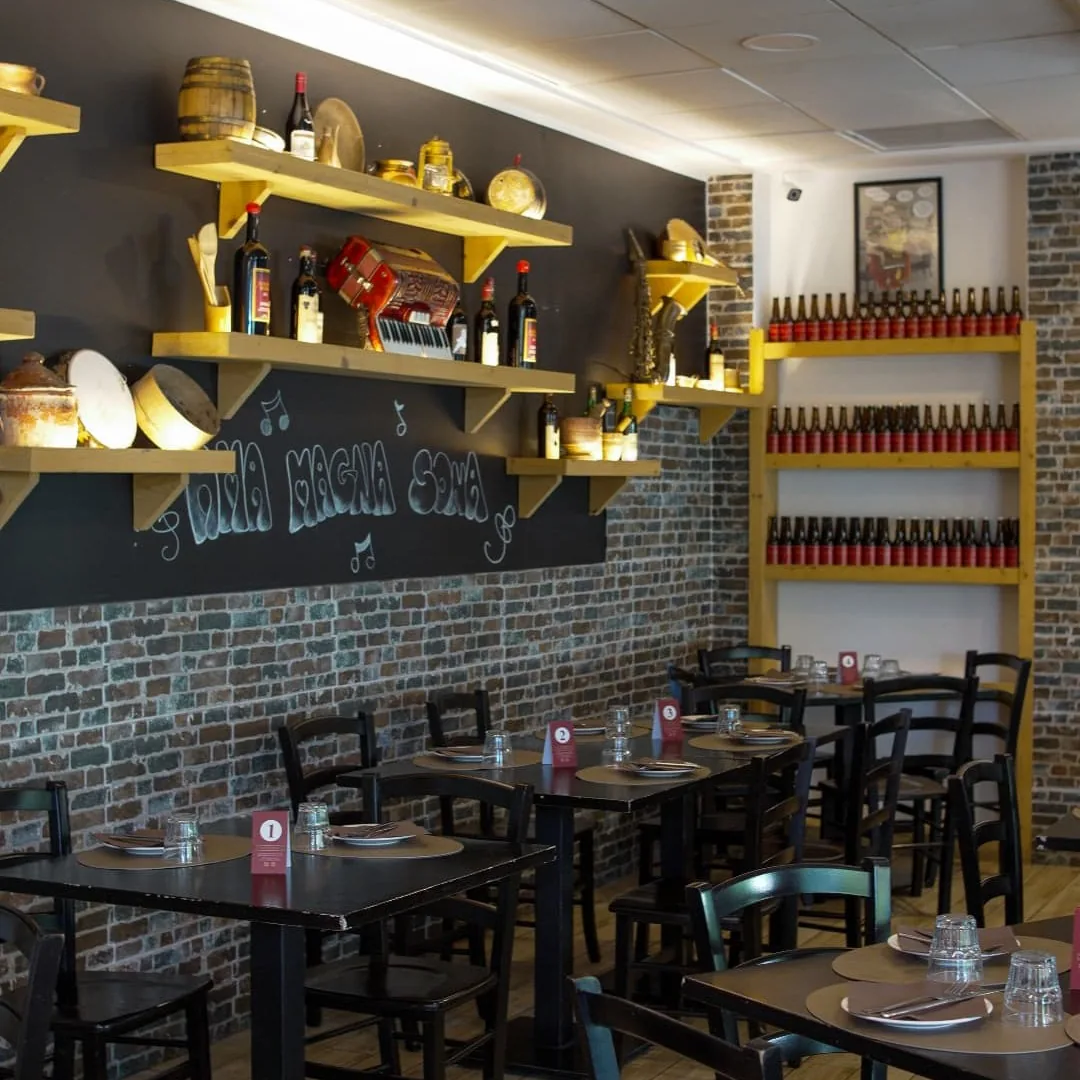 Interno della trattoria Magna Roma con le tavole apparecchiate